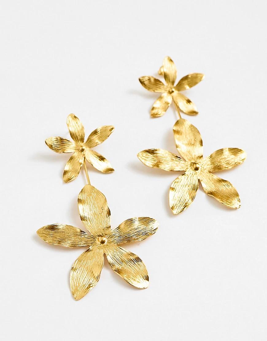 złote wiszące kolczyki w kształcie kwiatów tekstura