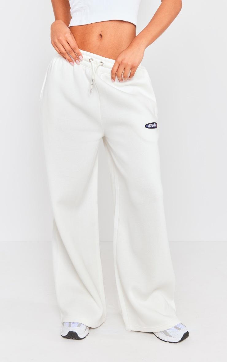 białe spodnie dresowe szerokie nogawki logo